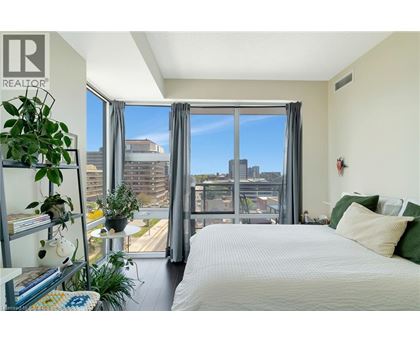 A bedroom with a large bed and a view of the city through the window.