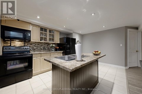 A modern kitchen with a granite countertop and stainless steel appliances.