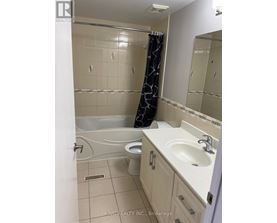 A bathroom with a white tub, sink, and toilet.