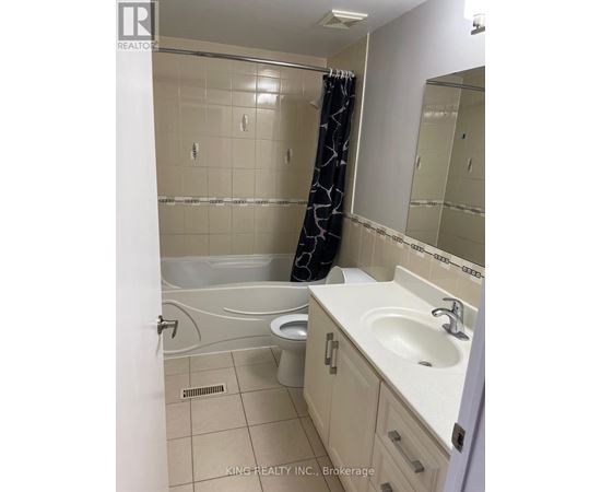 A bathroom with a white tub, sink, and toilet.