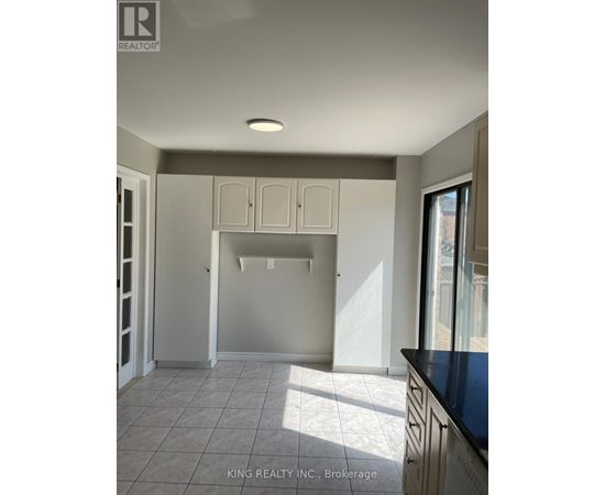 A kitchen with white cabinets and a black countertop.