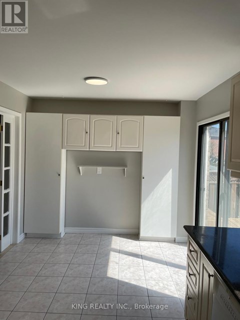 A kitchen with white cabinets and a black countertop.