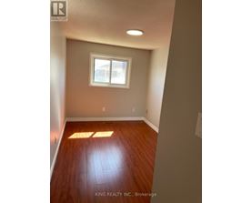 A room with a window and wooden floors.
