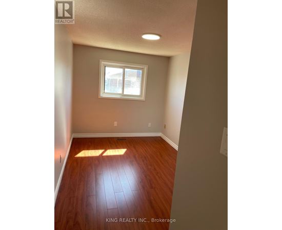 A room with a window and wooden floors.