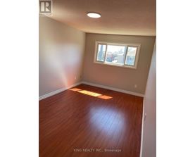 A room with a window and wooden flooring.