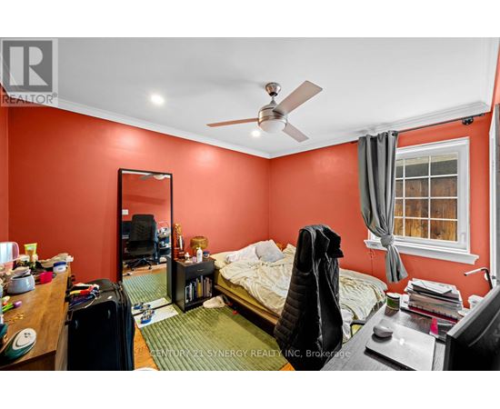 A bedroom with a bed, desk, and chair.