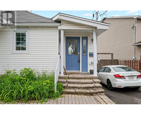 A white house with a blue door and a car parked in front.