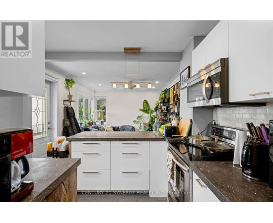 A kitchen with white cabinets and a black counter top.
