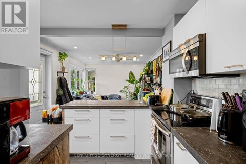 A kitchen with white cabinets and a black counter top.