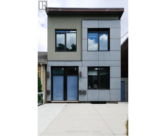 A modern two-story house with a flat roof and a grey exterior.