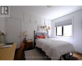 A bedroom with a bed, nightstand, and chair.