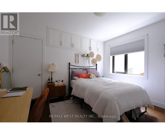 A bedroom with a bed, nightstand, and chair.