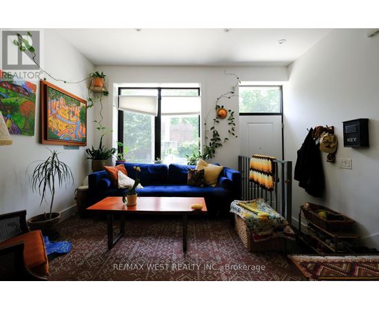A living room with a blue couch and a rug.