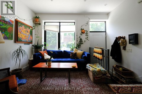 A living room with a blue couch and a rug.