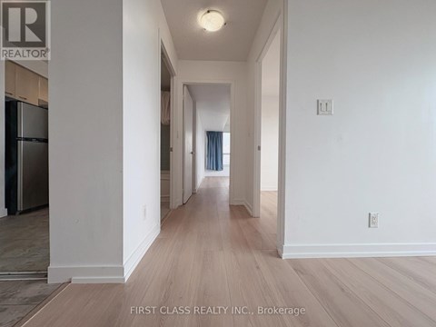 A long hallway with wood floors and white walls.