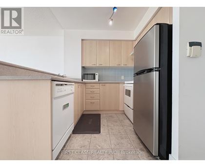 A kitchen with a refrigerator, microwave, and oven.