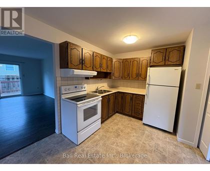 A kitchen with white appliances and wooden cabinets.