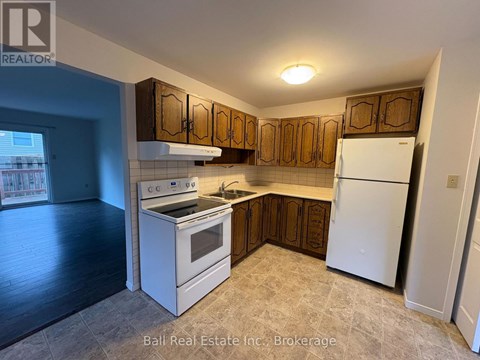 A kitchen with white appliances and wooden cabinets.