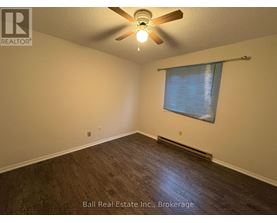 A room with a ceiling fan and a window with blinds.