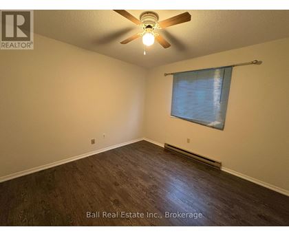 A room with a ceiling fan and a window with blinds.