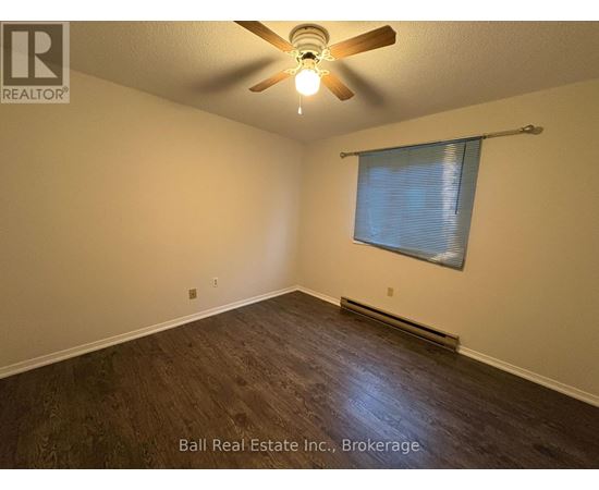A room with a ceiling fan and a window with blinds.