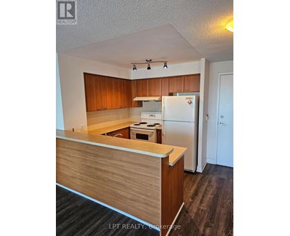 A kitchen with wooden cabinets and a white refrigerator.