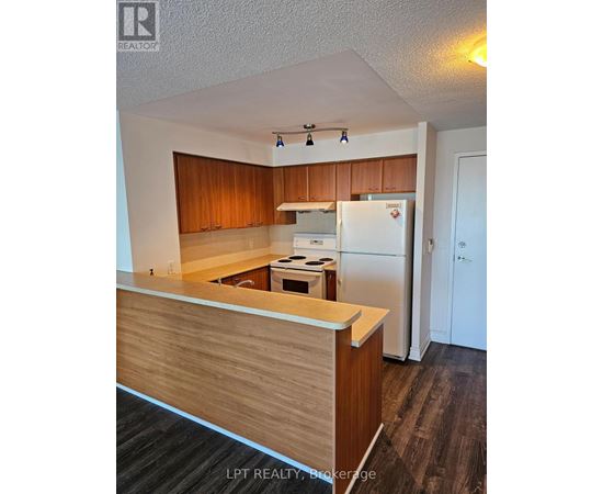 A kitchen with wooden cabinets and a white refrigerator.