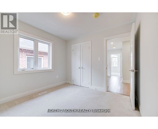 A white bedroom with a window and a door.