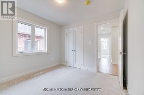 A white bedroom with a window and a door.