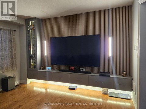 A modern living room with a large flat screen TV mounted on a striped wall.