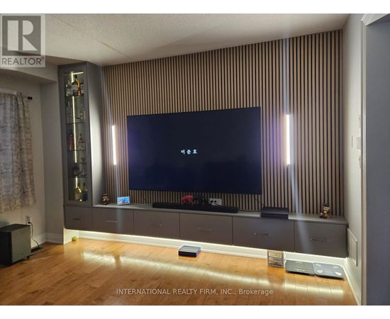 A modern living room with a flat screen TV mounted on a striped wall.