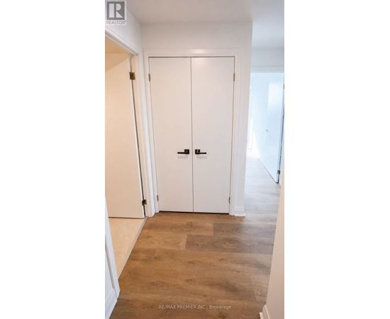 A white door with a black handle is in a room with wooden flooring.