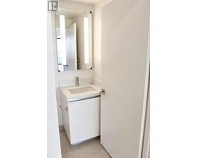A white sink in a white bathroom.