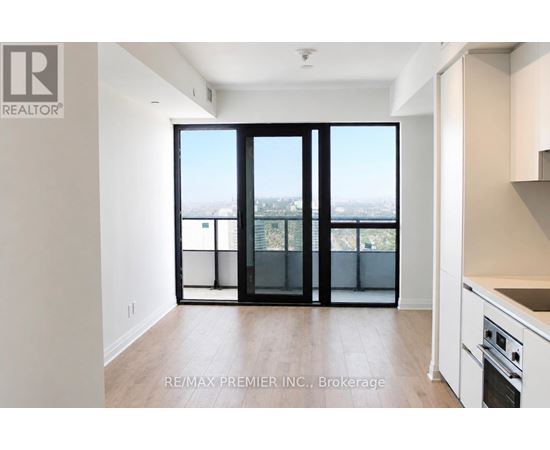 A spacious room with a view of the city through large windows.