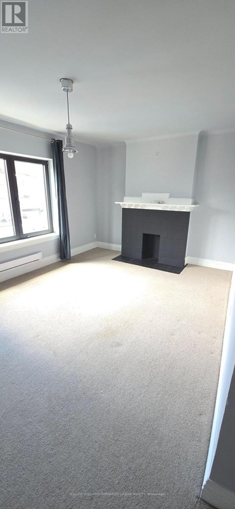 A room with a fireplace and a window.