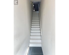 A hallway with a light on and a door at the end.