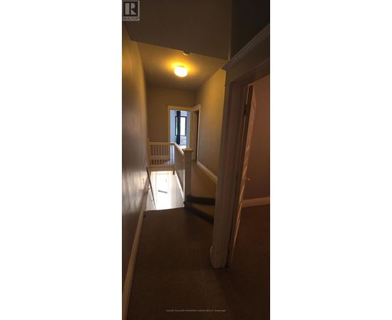 A hallway with a light on and a door at the end.