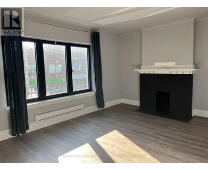 A living room with a fireplace and large windows.
