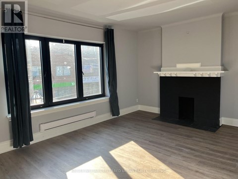 A living room with a fireplace and large windows.