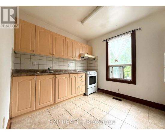 A kitchen with wooden cabinets and a tiled backsplash.
