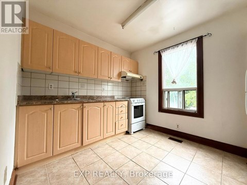 A kitchen with wooden cabinets and a tiled backsplash.