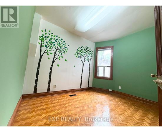 A room with a green wall and a tree mural on the wall.