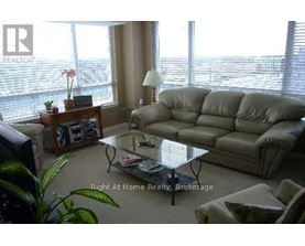 A living room with a couch, coffee table, and a window with blinds.