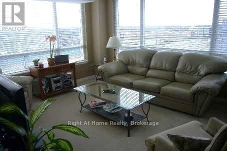A living room with a couch, coffee table, and a window with blinds.