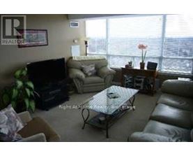 A living room with a couch, chair, and television.