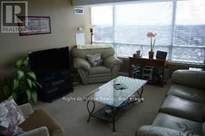 A living room with a couch, chair, and television.