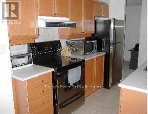A kitchen with wooden cabinets and black appliances.