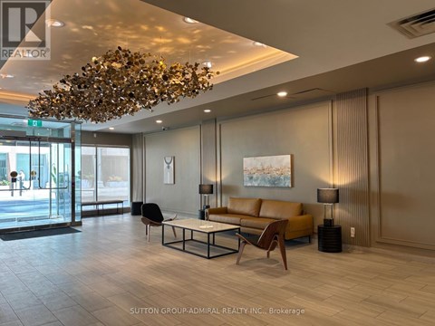 A modern living room with a large chandelier and a sofa.