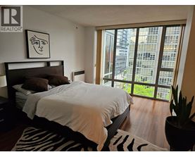 A bedroom with a large bed and a zebra print rug.
