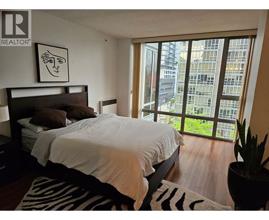 A bedroom with a large bed and a zebra print rug.